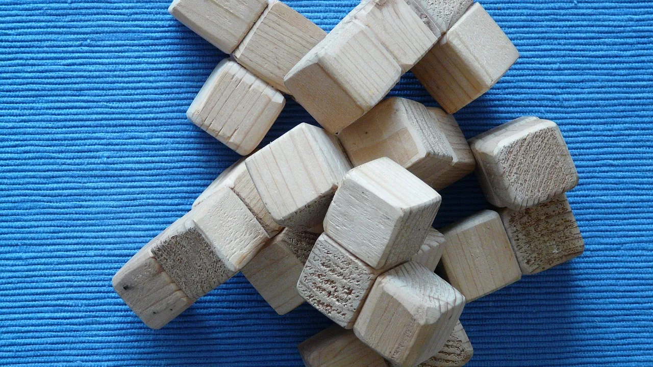 Cubes de bois bruts rassemblés en grappe sur un fond bleu.